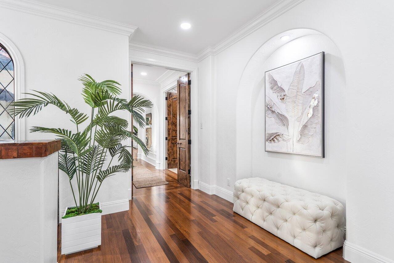 591 Phillips Drive Boca Raton, FL 33432 - Photo 30 of 90 a view of a hallway with wooden floor and a potted plant