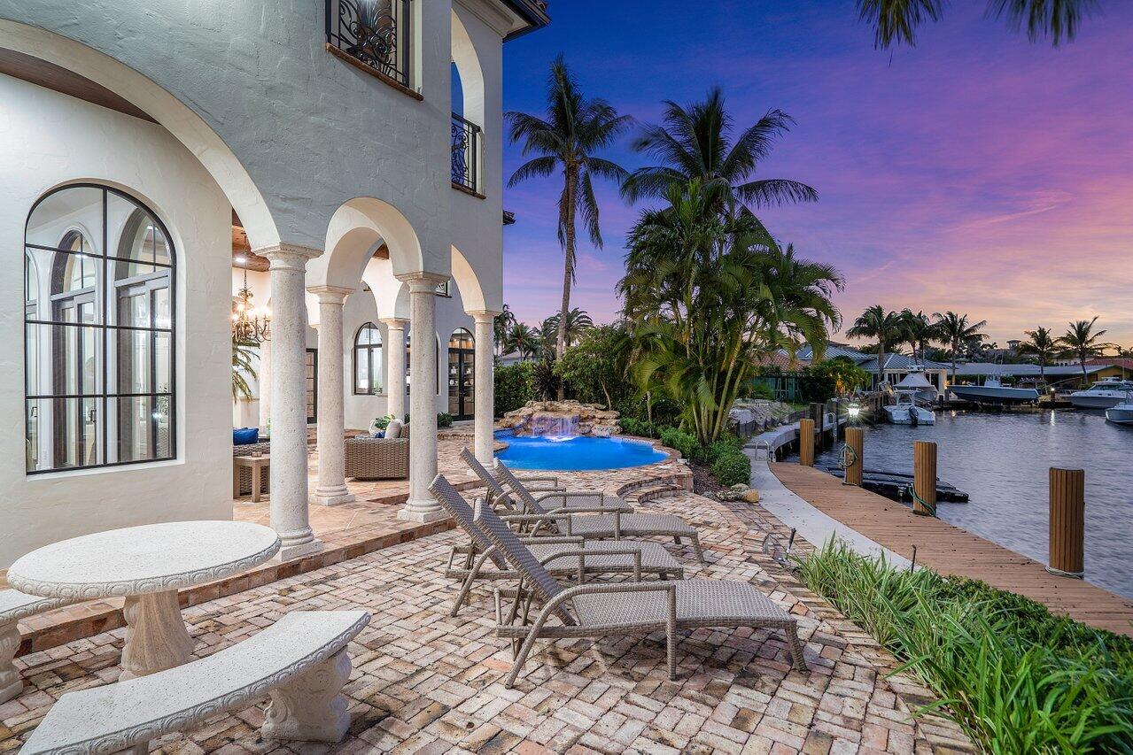 591 Phillips Drive Boca Raton, FL 33432 - Photo 77 of 90 a view of a patio with table and chairs potted plants and a fountain