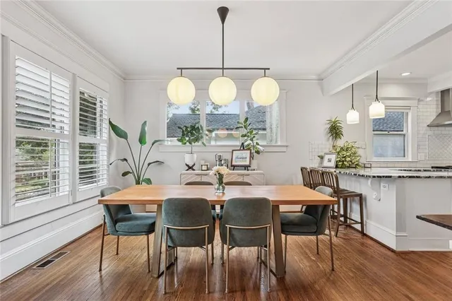 a dining room filled chandelier and wooden floor