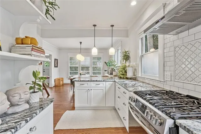 a kitchen with stainless steel appliances granite countertop a stove a sink and a refrigerator