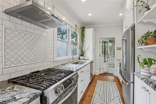 a kitchen with a stove and a white wooden cabinets