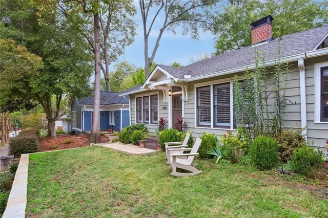 a view of a house with a yard and sitting area