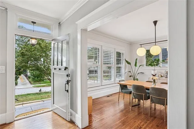 a dining room with wooden floor a glass table and chairs