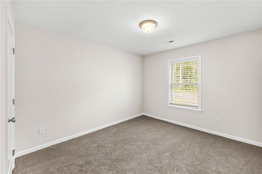 113 Crofton Court Easley, SC 29642 - Photo 14 of 33 This cozy bedroom offers a tranquil retreat with soft carpet and natural light filtering through the window.