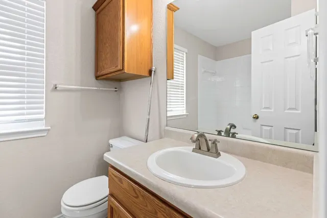 a bathroom with a sink a toilet and mirror
