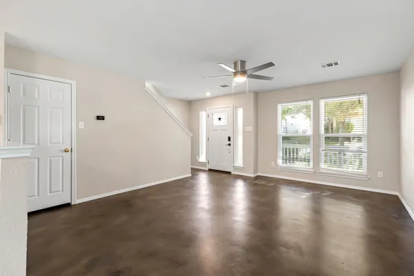 an empty room with wooden floor and windows