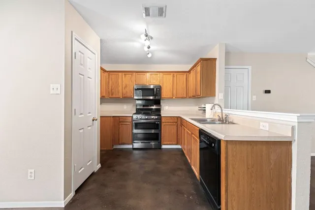 a kitchen with stainless steel appliances granite countertop a sink stove and refrigerator