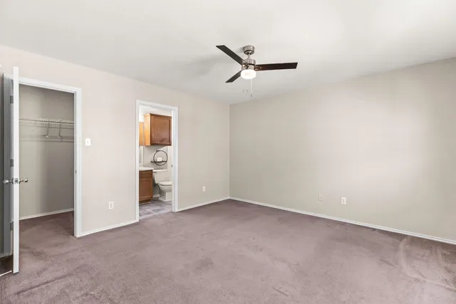 an empty room with closet and windows