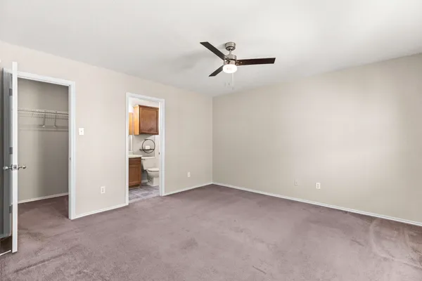 an empty room with closet and windows