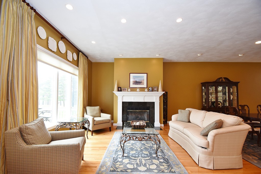 97 Hawthorne Village Road, Unit 97 Nashua, NH 03062 - Photo 8 of 30 a living room with furniture fireplace and a large window