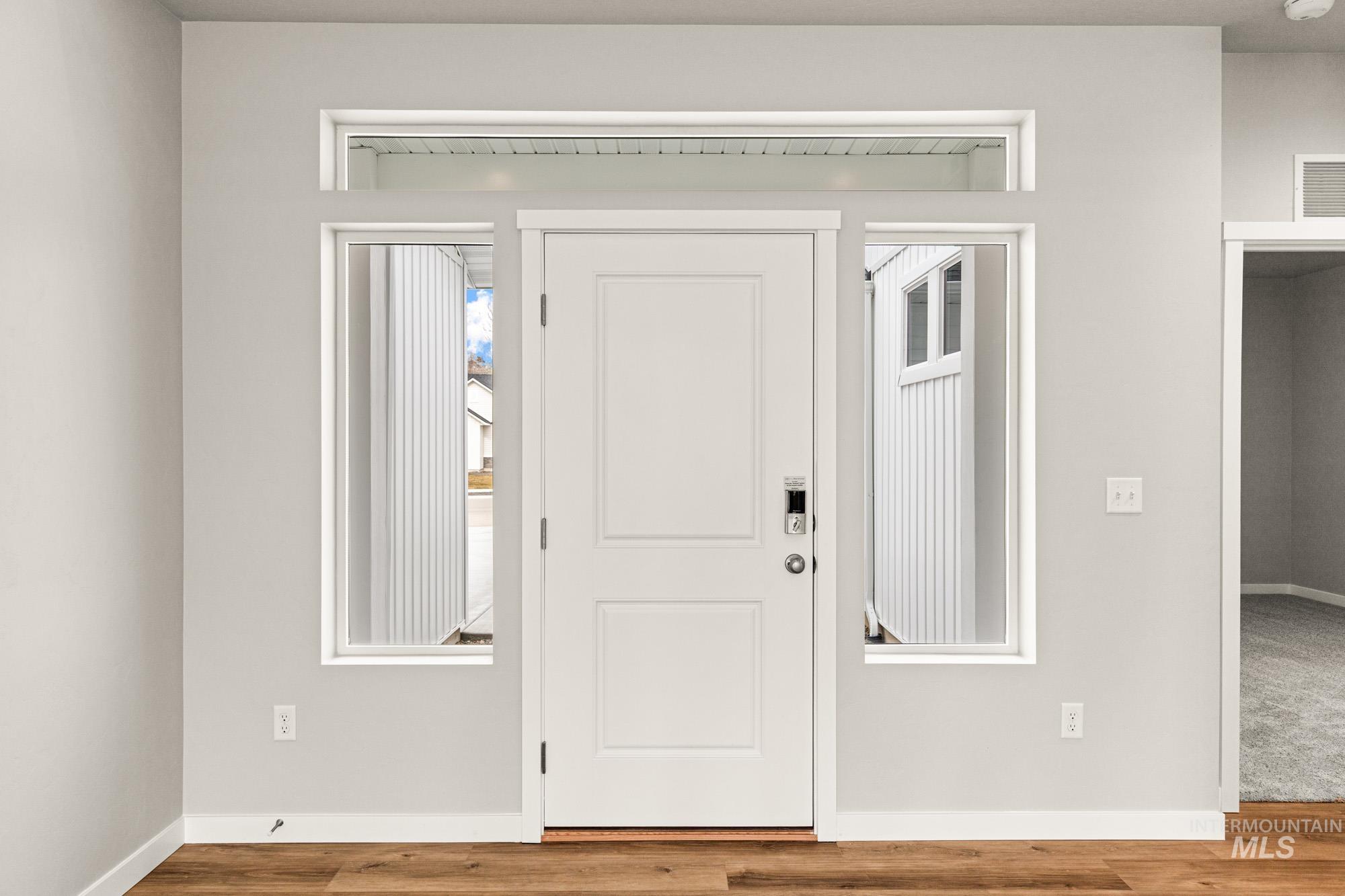 448 Merlin Court Middleton, ID 83644 - Photo 2 of 29 Entryway featuring a paneled door with sidelight windows, transom window, and wood-finish flooring