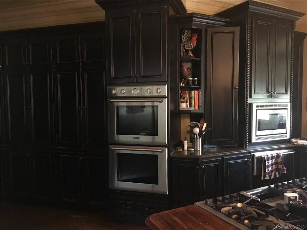 1801 Ruben Road Monroe, NC 28112 - Photo 10 of 14 a kitchen with granite countertop wooden cabinets and black appliances