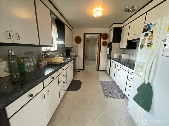 a large white kitchen with stainless steel appliances