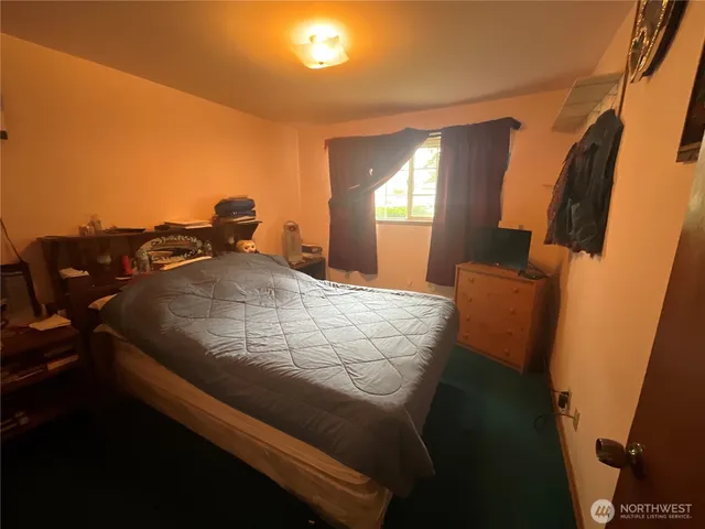 a bed sitting in a bedroom next to a window