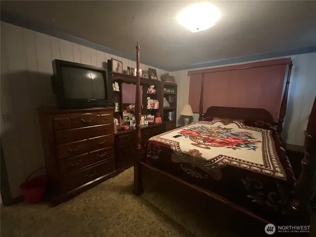 a bedroom with a bed and a flat tv screen