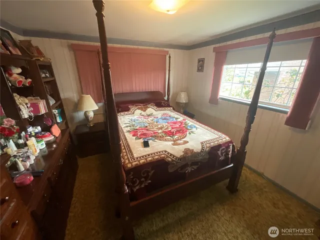 a bedroom with a bed dresser and a window