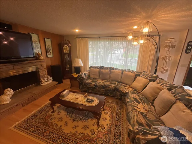 a living room with furniture a flat screen tv and a fireplace