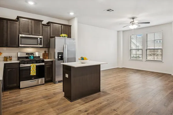 a kitchen with granite countertop a refrigerator stove top oven and sink