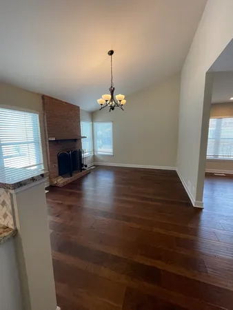a view of a livingroom with a fireplace wooden floor and a window