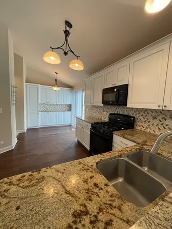 a kitchen with stainless steel appliances kitchen island granite countertop a sink and a stove