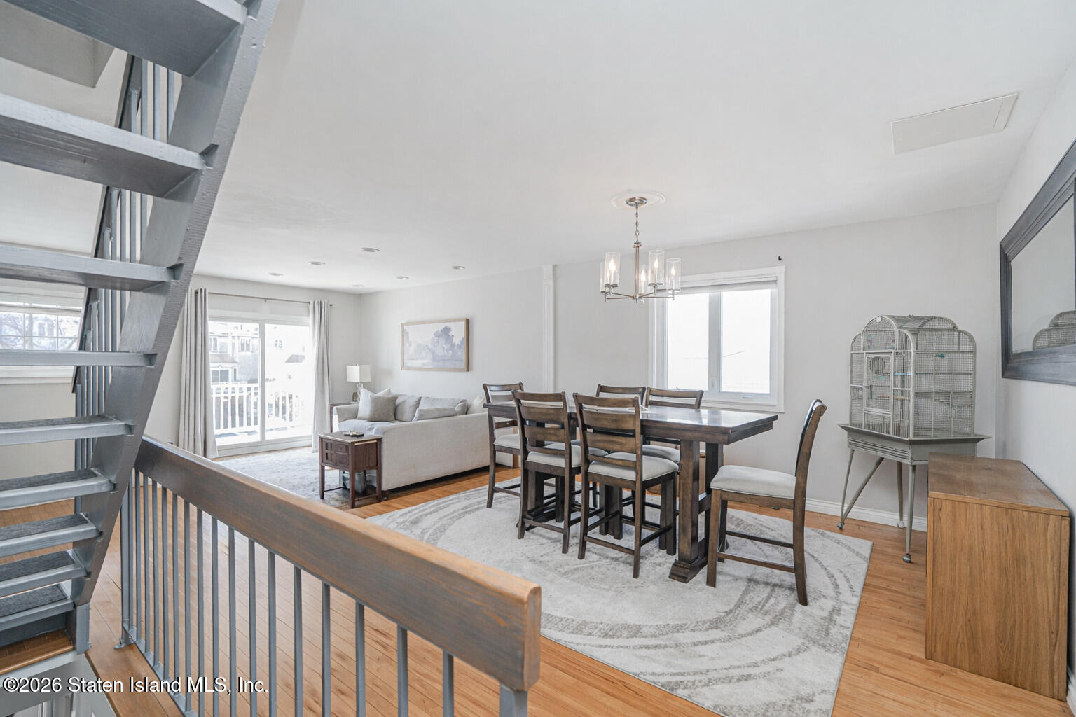 631 Travis Avenue Staten Island, NY 10314 - Photo 28 of 75 a view of a dining room and livingroom with furniture wooden floor a rug a painting and a chandelier