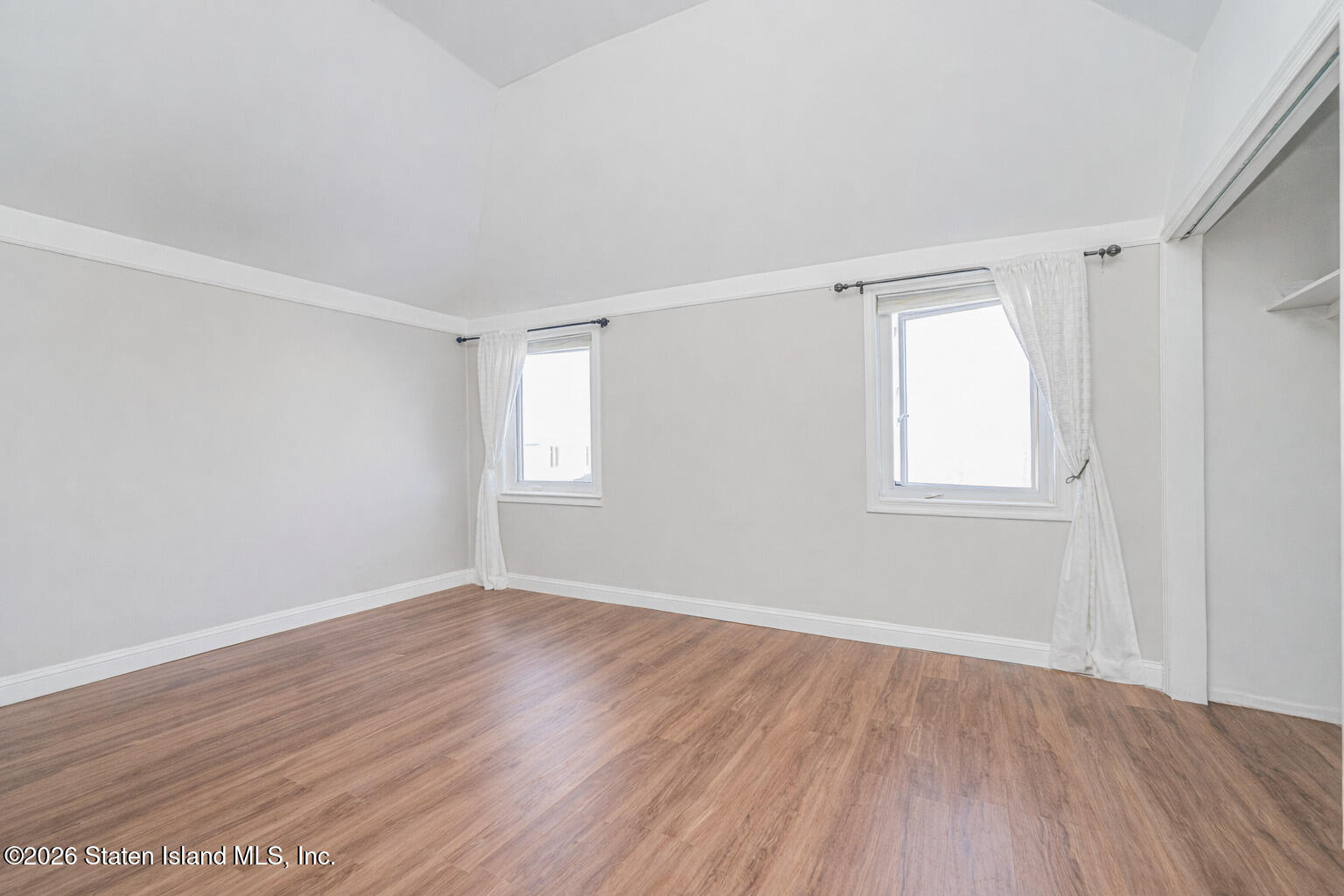 631 Travis Avenue Staten Island, NY 10314 - Photo 48 of 75 a view of an empty room with wooden floor and a window