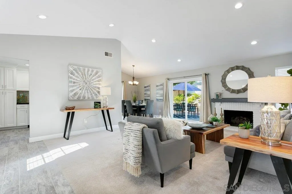 a living room with furniture a fireplace and a large window