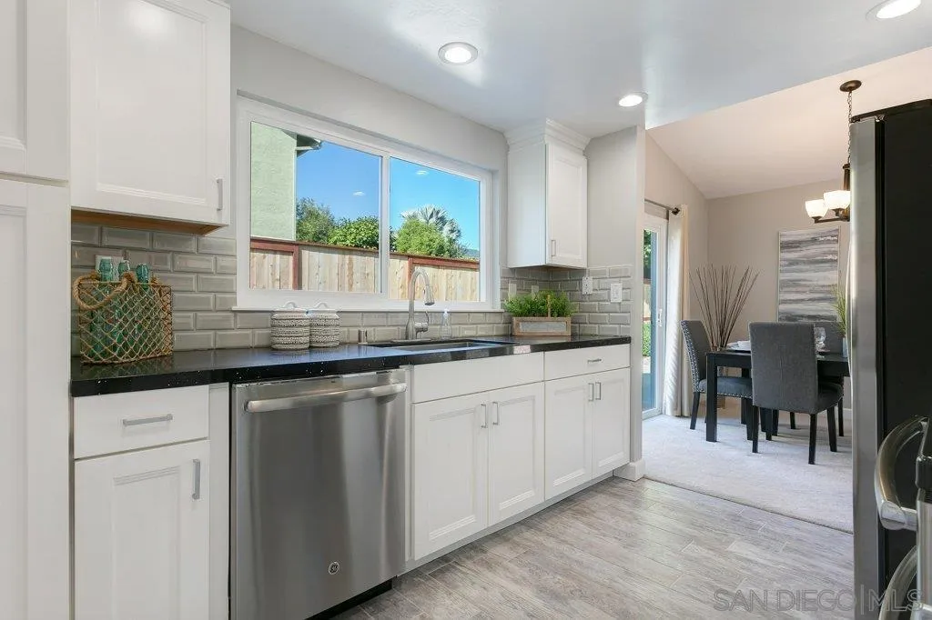 2725 Glasgow Drive Carlsbad, CA 92010 - Photo 11 of 29 a kitchen with granite countertop white cabinets and white appliances