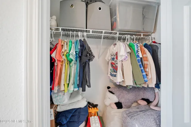 a view of walk in closet with clothes and shoes