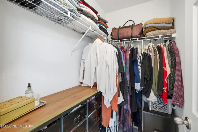 a view of walk in closet with clothes