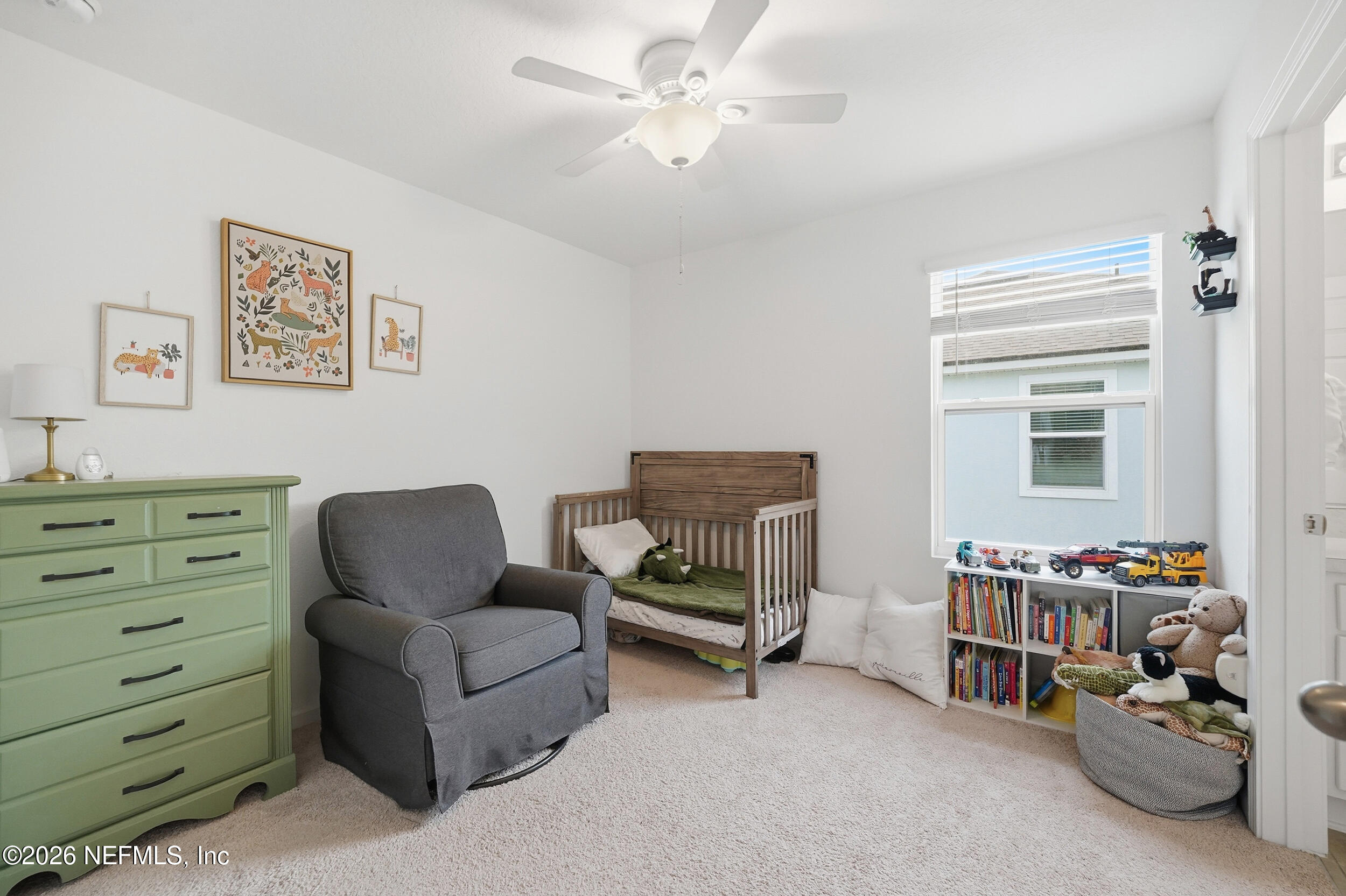 8323 Asteroid Street Jacksonville, FL 32256 - Photo 19 of 27 a living room with furniture a baby crib and a window
