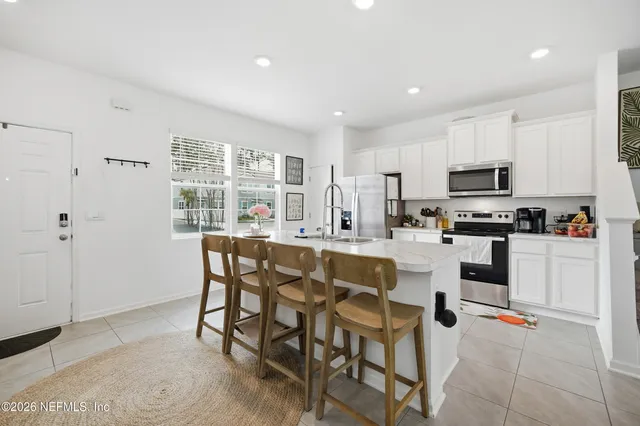 a kitchen with granite countertop white cabinets and stainless steel appliances
