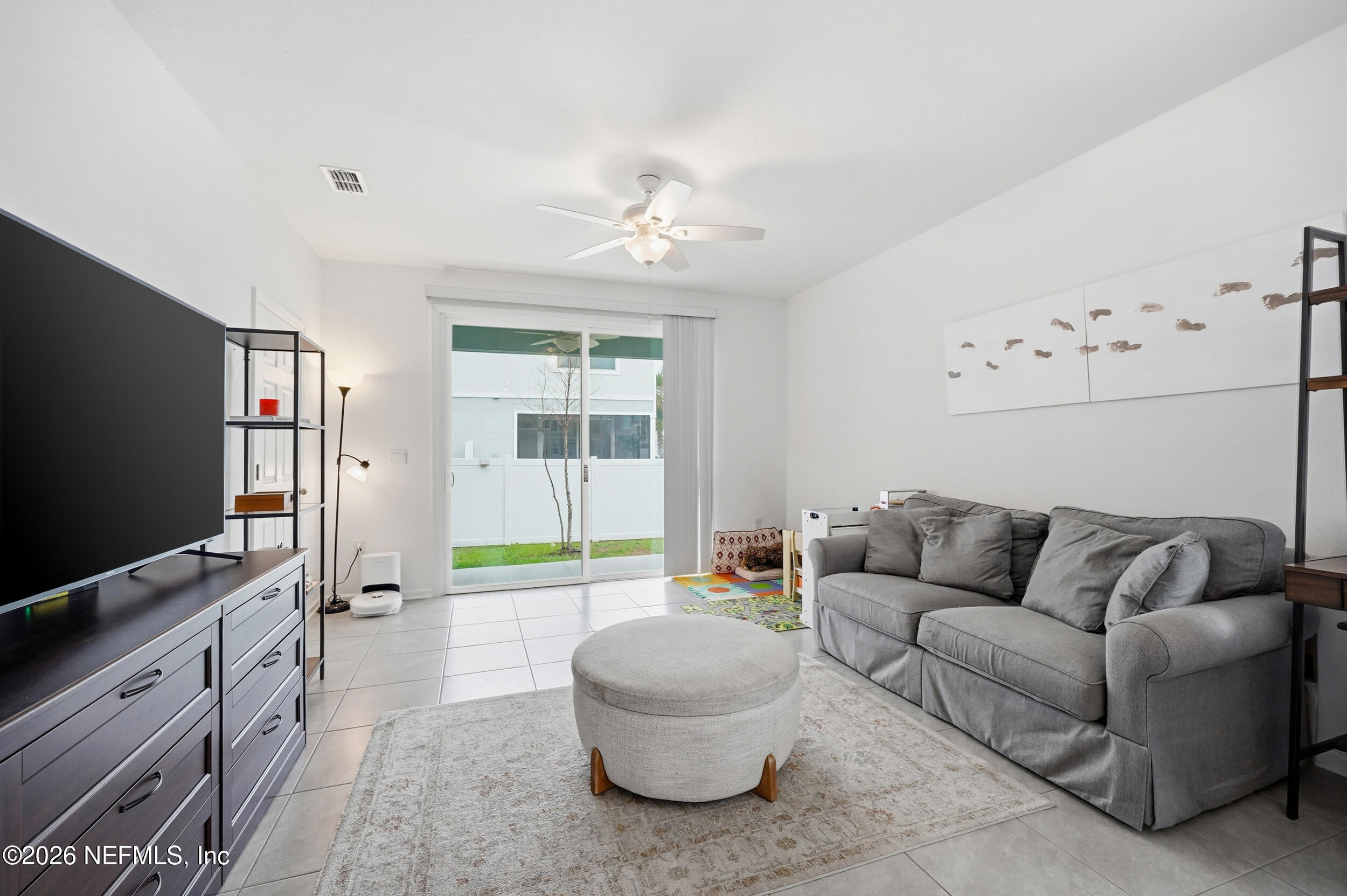 8323 Asteroid Street Jacksonville, FL 32256 - Photo 9 of 27 a living room with furniture and a flat screen tv