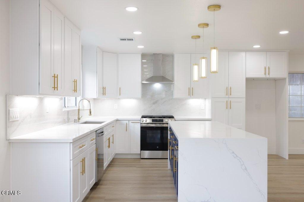6015 Peppertree Lane Simi Valley, CA 93063 - Photo 3 of 15 a kitchen with a sink white cabinets and stainless steel appliances