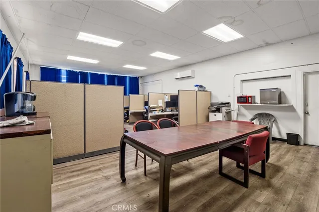 a kitchen with stainless steel appliances granite countertop a refrigerator a stove a sink dishwasher a dining table and chairs with wooden floor