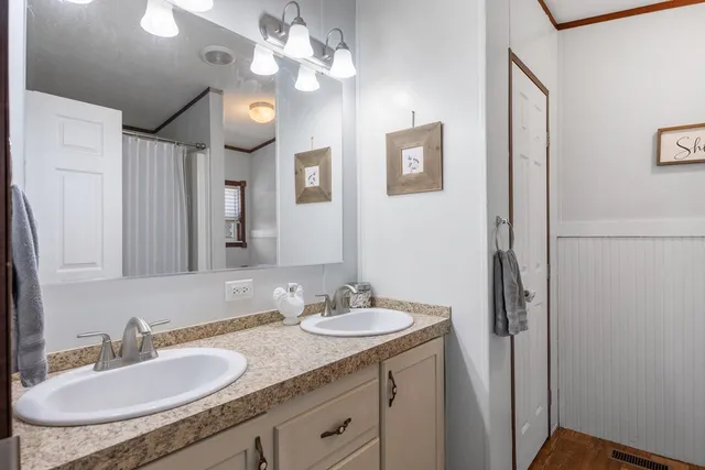 a bathroom with a granite countertop sink a light fixture and a mirror