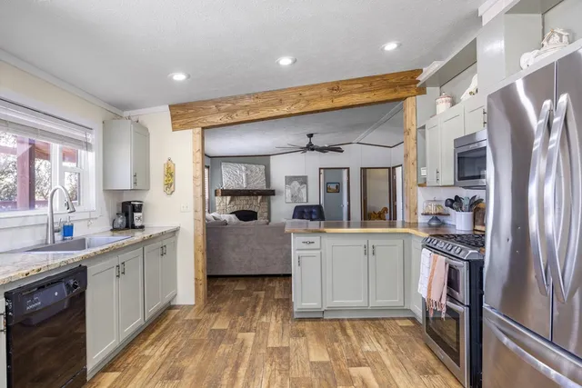 a kitchen with stainless steel appliances granite countertop a refrigerator and a sink