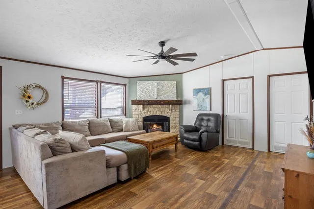 a living room with furniture a large window and a fireplace