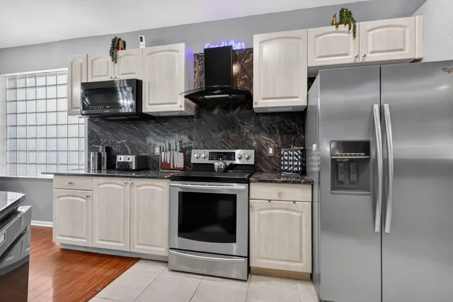 a kitchen with stainless steel appliances granite countertop a refrigerator stove and sink