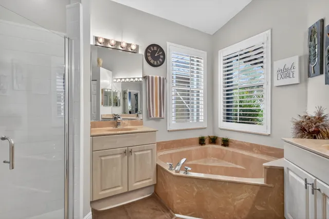 a spacious bathroom with a tub a sink and a large mirror