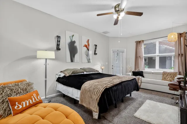 a bedroom with a bed couches and window