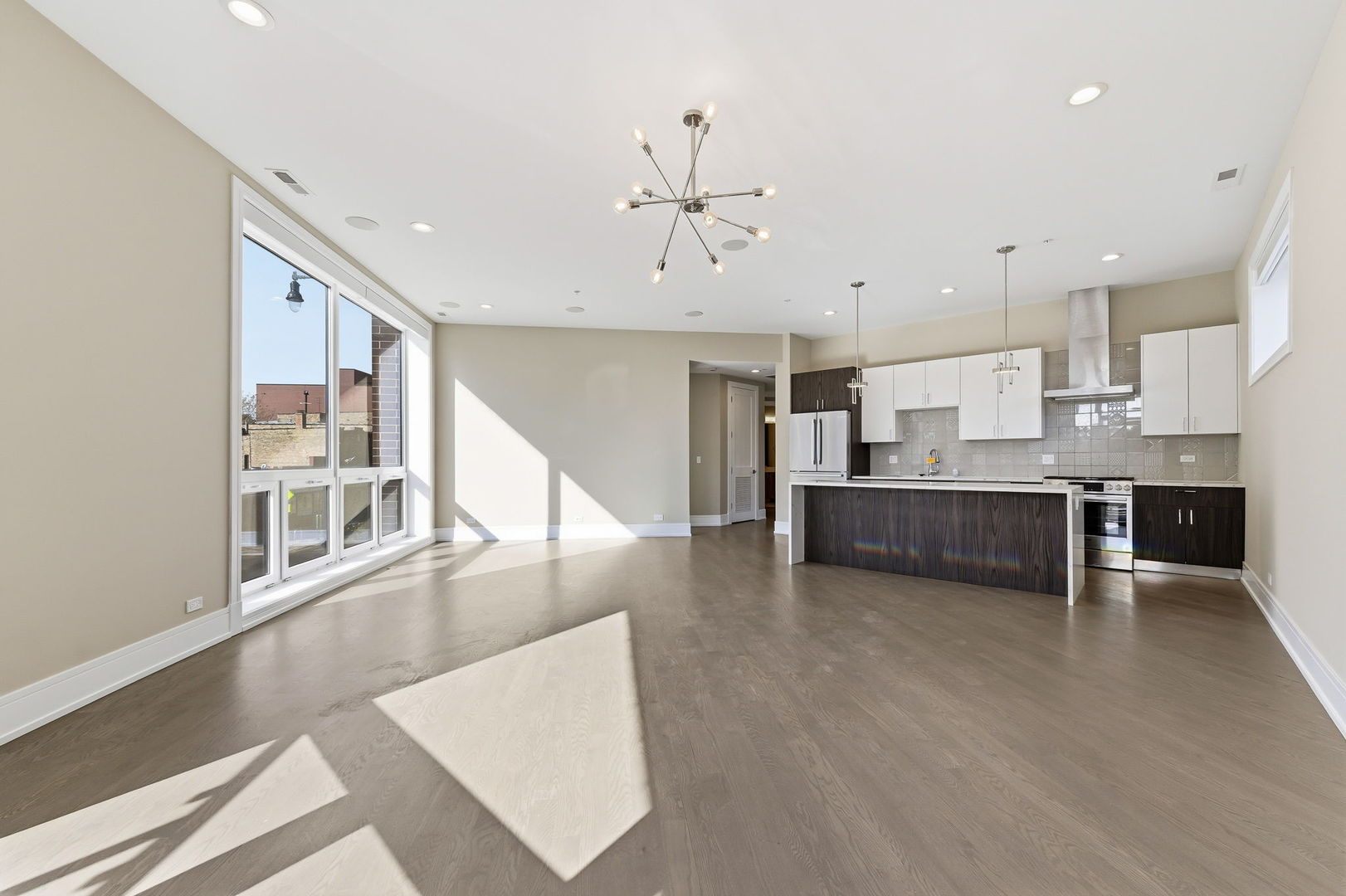 3101 North Ridgeway Avenue, Unit 2A Chicago, IL 60618 - Photo 3 of 11 a view of a kitchen with kitchen island stainless steel appliances wooden floor dining table and chairs