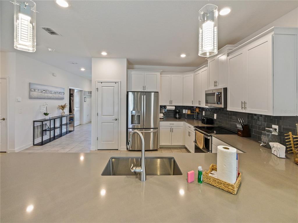 9084 Sommerset Hills Drive Davenport, FL 33896 - Photo 18 of 63 a kitchen with counter top space cabinets and stainless steel appliances