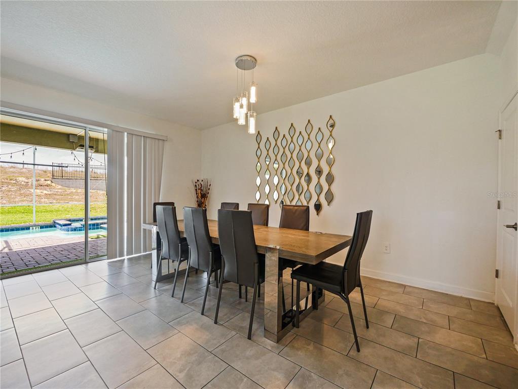 9084 Sommerset Hills Drive Davenport, FL 33896 - Photo 20 of 63 a view of a dining room with furniture and chandelier