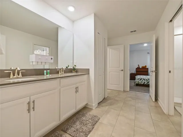a en suite bathroom with a double vanity sink and a mirror