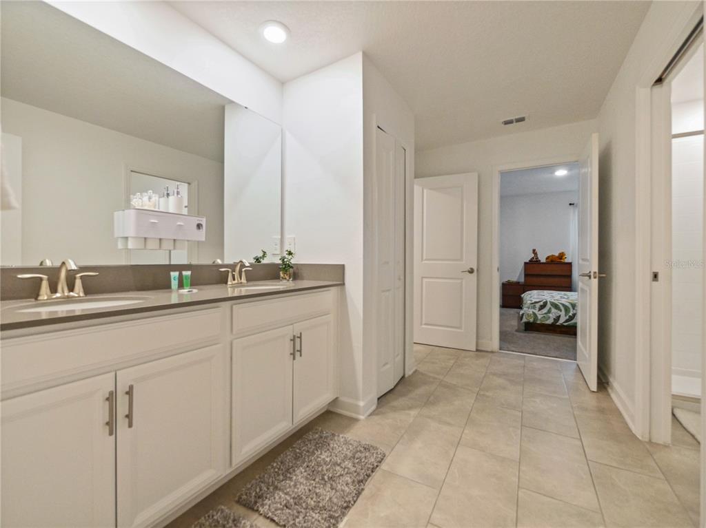 9084 Sommerset Hills Drive Davenport, FL 33896 - Photo 26 of 63 a spacious bathroom with a double vanity sink and a mirror