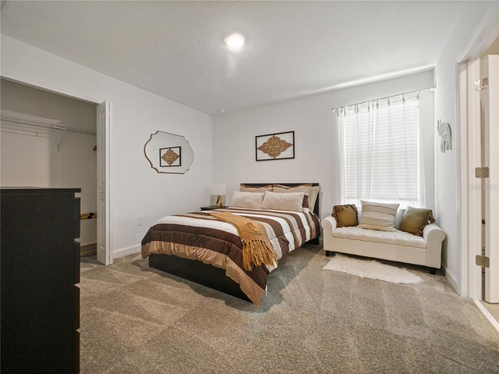 9084 Sommerset Hills Drive Davenport, FL 33896 - Photo 28 of 63 a bedroom with a bed couch and a window