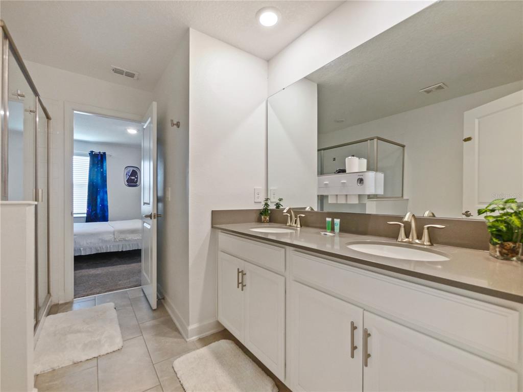 9084 Sommerset Hills Drive Davenport, FL 33896 - Photo 30 of 63 a en suite bathroom with double sink and a mirror