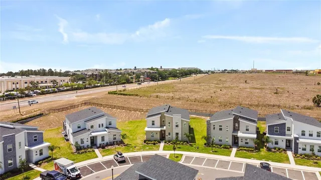 an aerial view of residential houses with outdoor space and ocean view