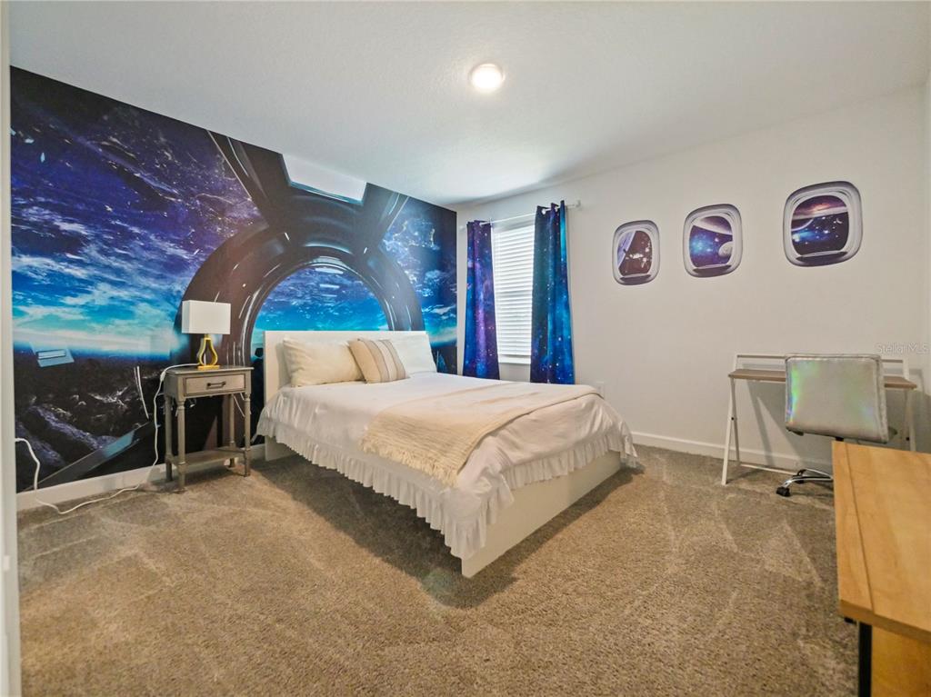 9084 Sommerset Hills Drive Davenport, FL 33896 - Photo 32 of 63 a bed sitting in a room next to a lamp